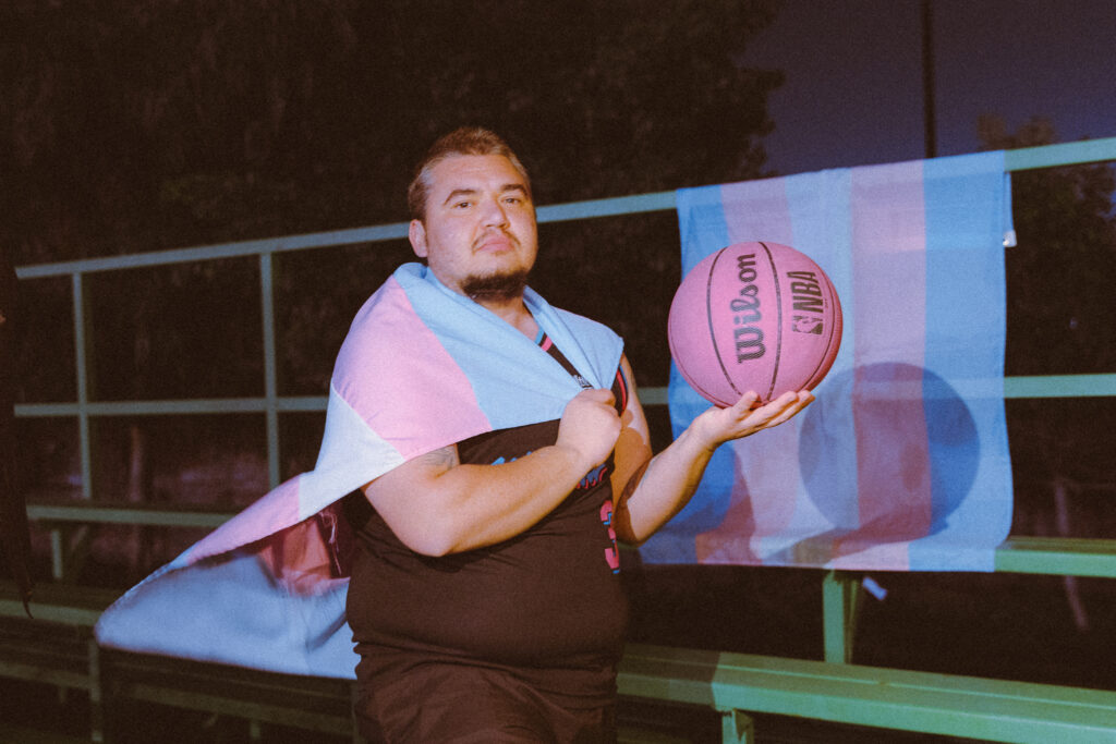 Portrait with basketball and trans flag in background